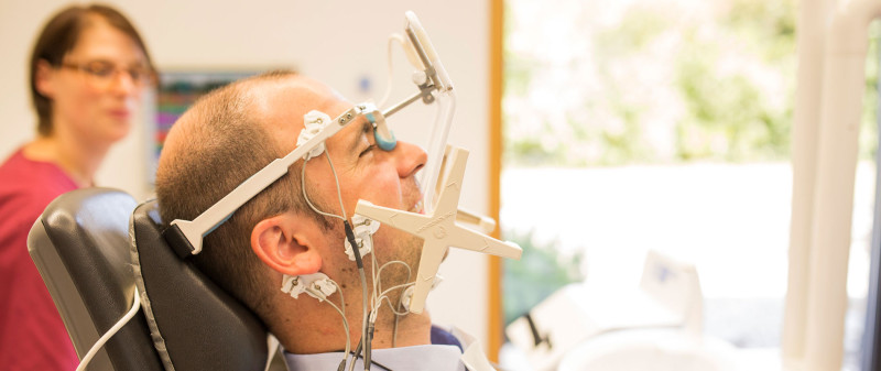 Patient bei CMD-Schienenanpassung in Zahnarztpraxis.