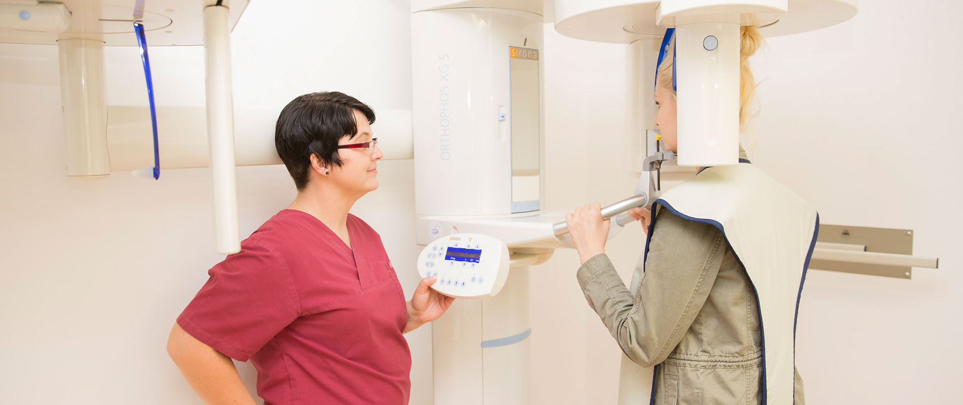 Zahnärztin erklärt Patientin die moderne Röntgentechnik in der Zahnarztpraxis.