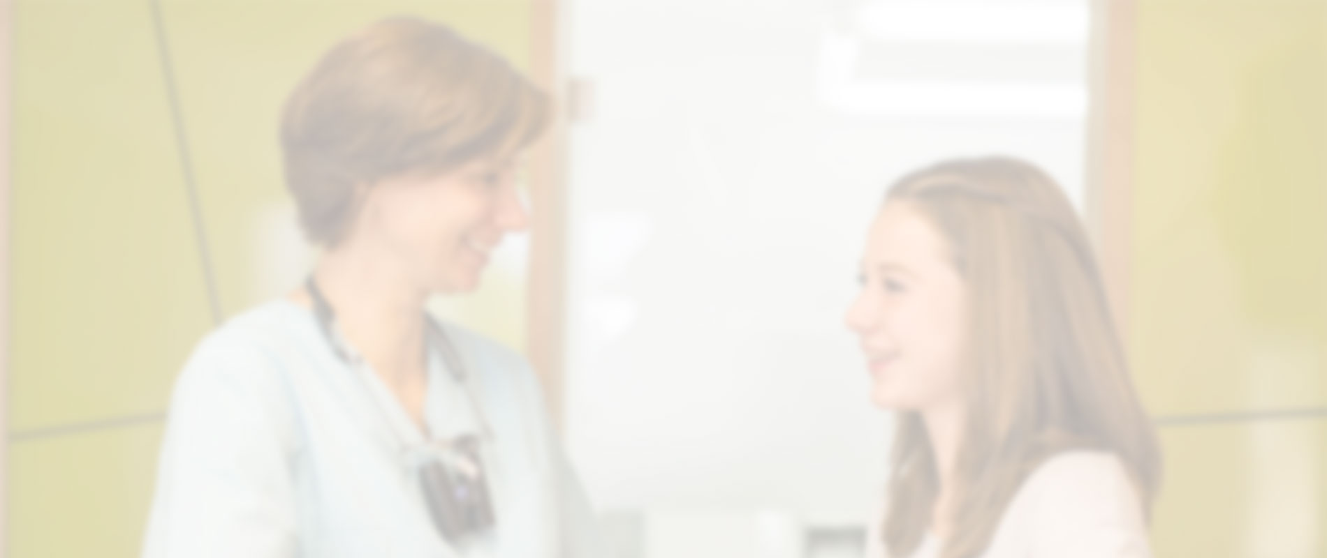 Zahnärztin im Gespräch mit junger Patientin in der Praxis.
