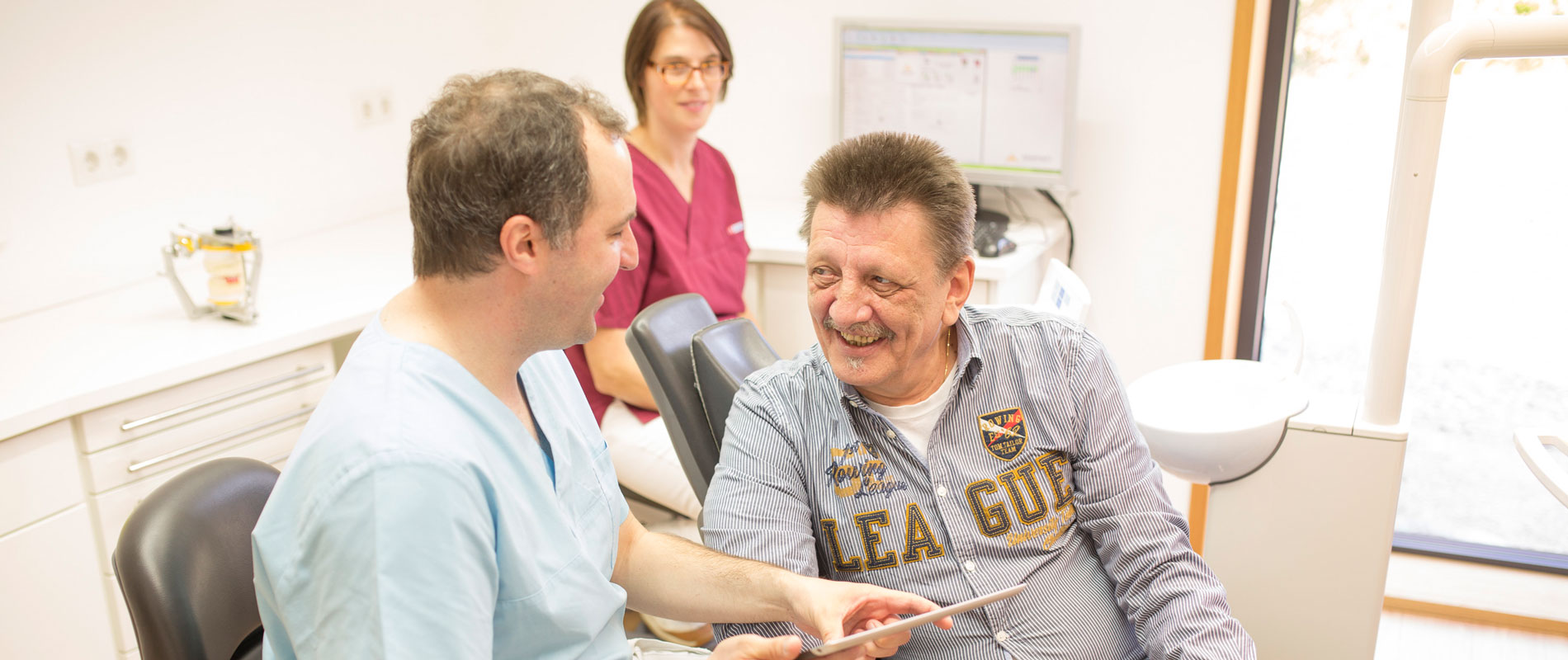 Zahnarzt berät Patienten zur Implantologie in der Praxis.