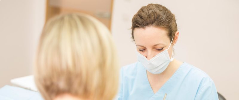 Zahnärztin behandelt Patientin mit  Parodontitis in in Hollfelder Zahnarztpraxis.