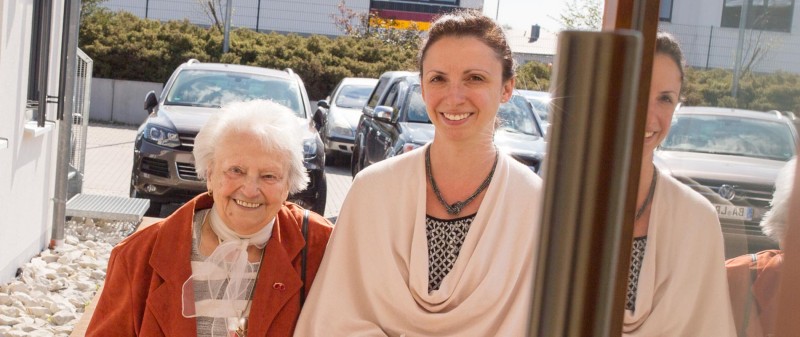 Seniorin und Zahnarzthelferin betreten Zahnarztpraxis in Hollfeld.