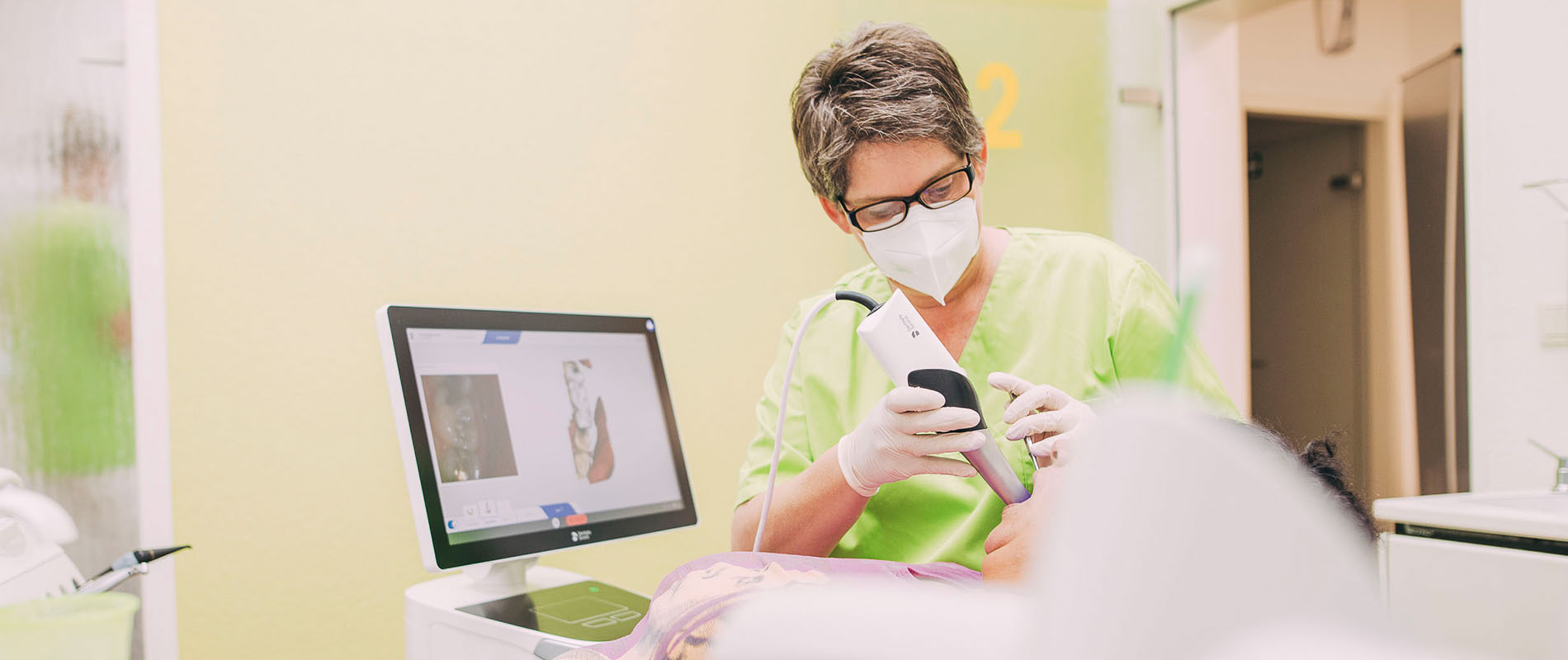 Zahnarzt nutzt Intraoralscanner für digitalen Zahnabdruck in Praxis Hollfeld.